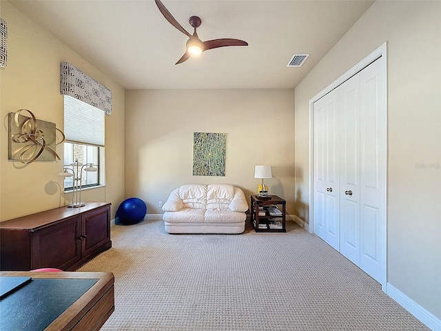 living area featuring ceiling fan and light colored carpet