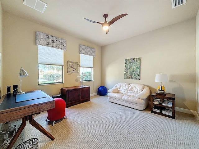 carpeted home office featuring ceiling fan