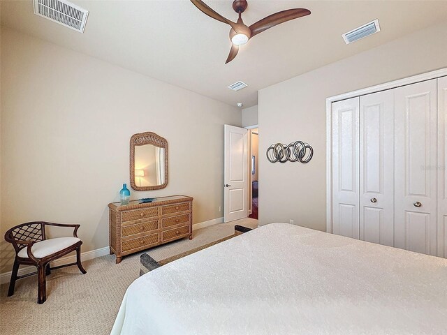 carpeted bedroom with ceiling fan and a closet