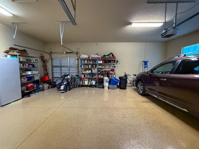 garage with a garage door opener and fridge