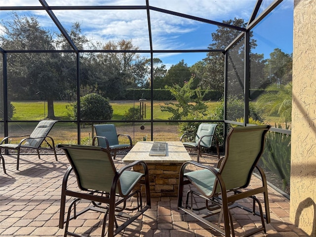 view of patio / terrace featuring glass enclosure and exterior bar