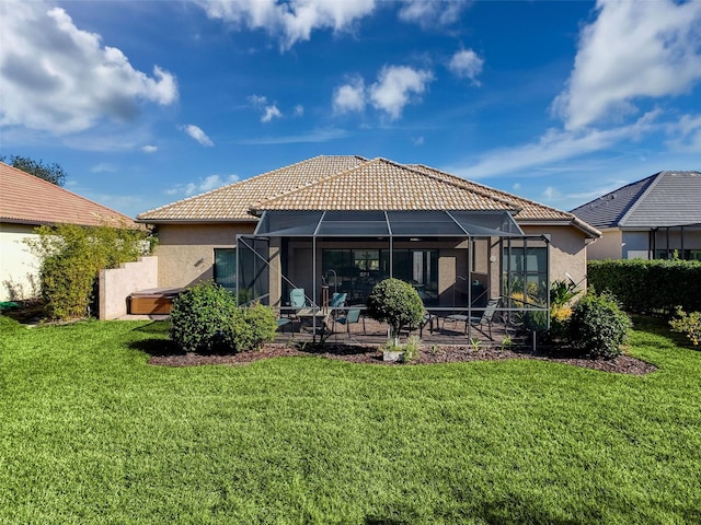 rear view of property with glass enclosure, a yard, and a patio