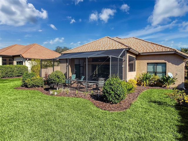 back of property with glass enclosure, a patio area, and a lawn