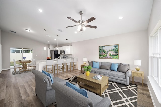 living room with dark hardwood / wood-style flooring, vaulted ceiling, and ceiling fan