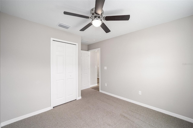 unfurnished bedroom featuring carpet floors, a closet, and ceiling fan