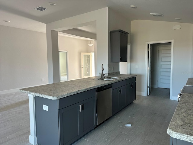 kitchen featuring stainless steel dishwasher, sink, light hardwood / wood-style flooring, gray cabinets, and lofted ceiling