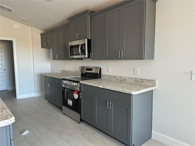 kitchen featuring stainless steel appliances and gray cabinets