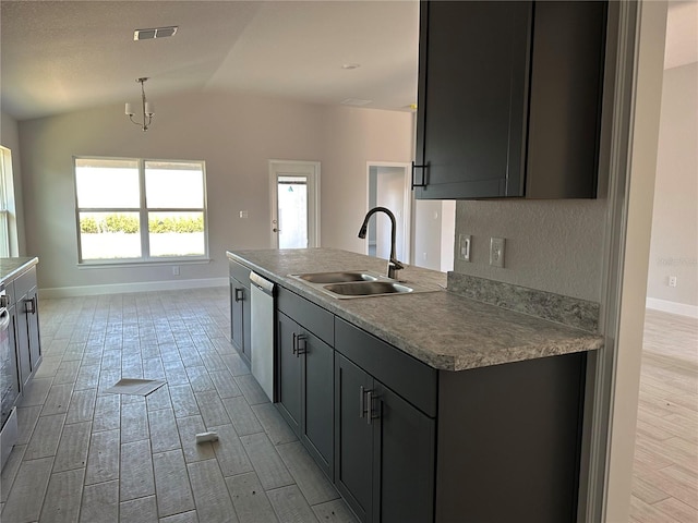 kitchen with light wood-type flooring, stainless steel dishwasher, vaulted ceiling, sink, and an island with sink