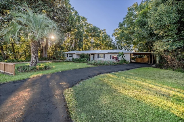 ranch-style home with a front yard and a carport