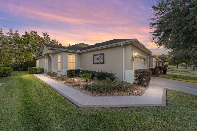 property exterior at dusk with a garage and a lawn