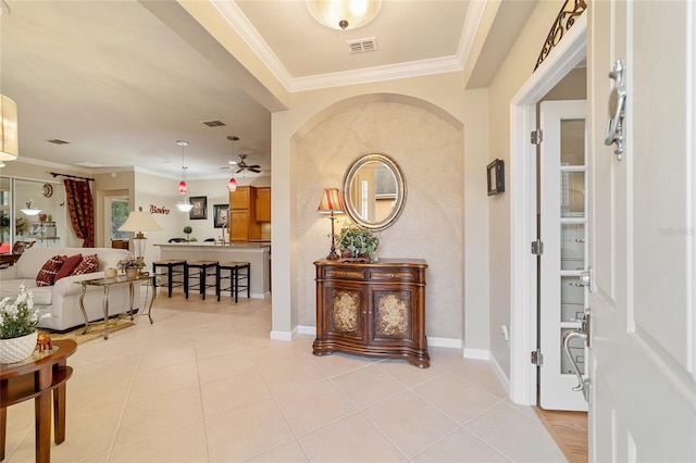 tiled foyer with ceiling fan and ornamental molding