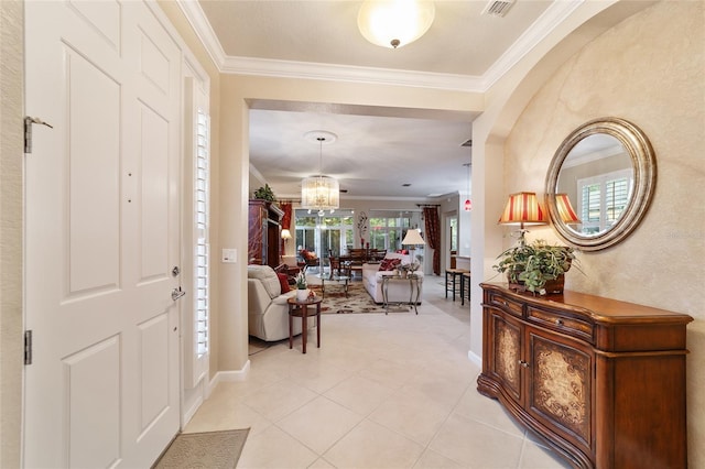 entryway featuring light tile patterned floors, a chandelier, and ornamental molding