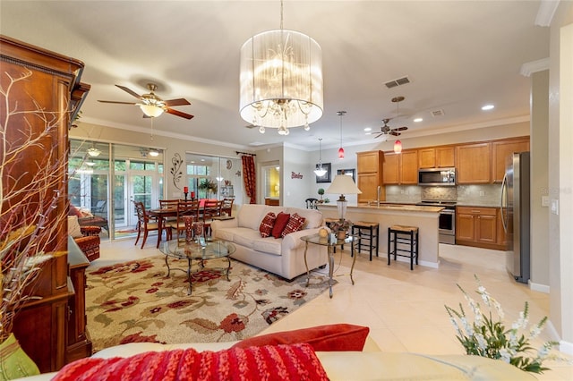 living room with ceiling fan with notable chandelier, crown molding, and sink