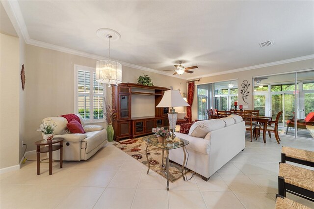 living room with crown molding, light tile patterned flooring, and ceiling fan with notable chandelier