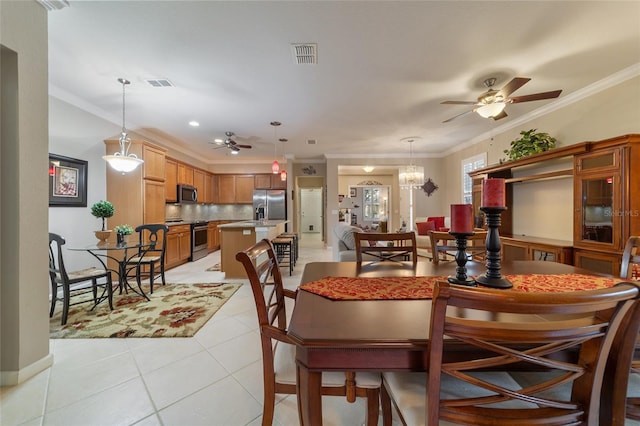 tiled dining area with ceiling fan with notable chandelier and ornamental molding