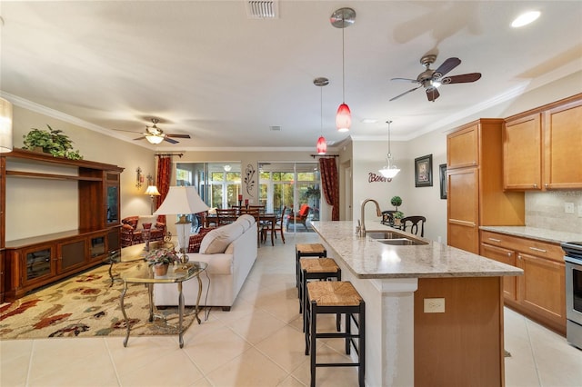 kitchen featuring light stone countertops, a breakfast bar, crown molding, and sink