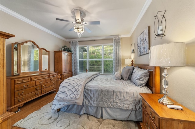 bedroom featuring hardwood / wood-style floors, ceiling fan, and crown molding