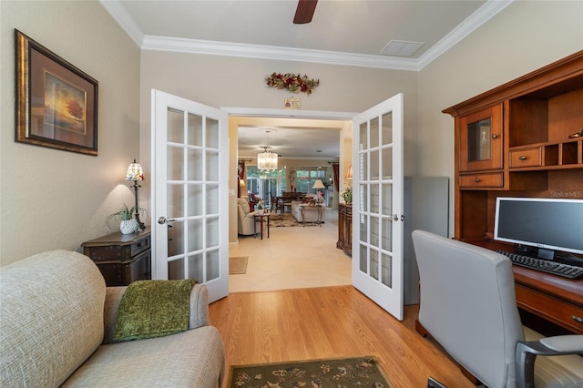 office with light hardwood / wood-style floors, ornamental molding, and french doors