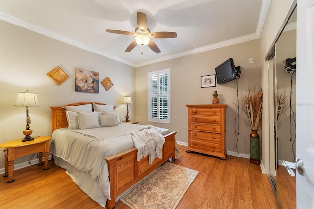 bedroom featuring a closet, light hardwood / wood-style floors, ceiling fan, and crown molding