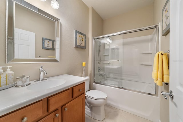 full bathroom with tile patterned floors, vanity, toilet, and bath / shower combo with glass door