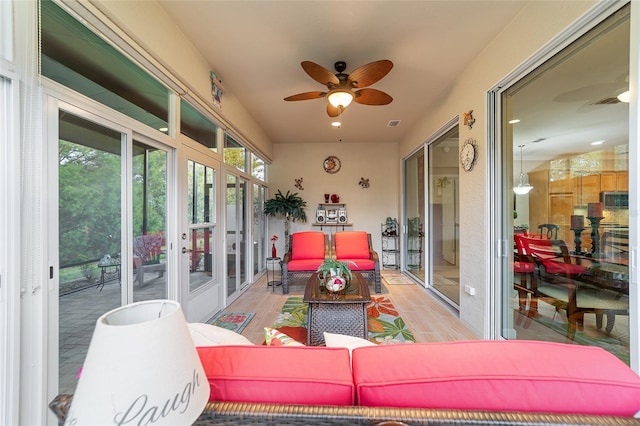 sunroom / solarium featuring ceiling fan