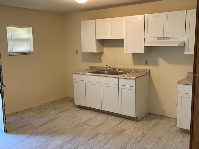 kitchen featuring white cabinetry and sink