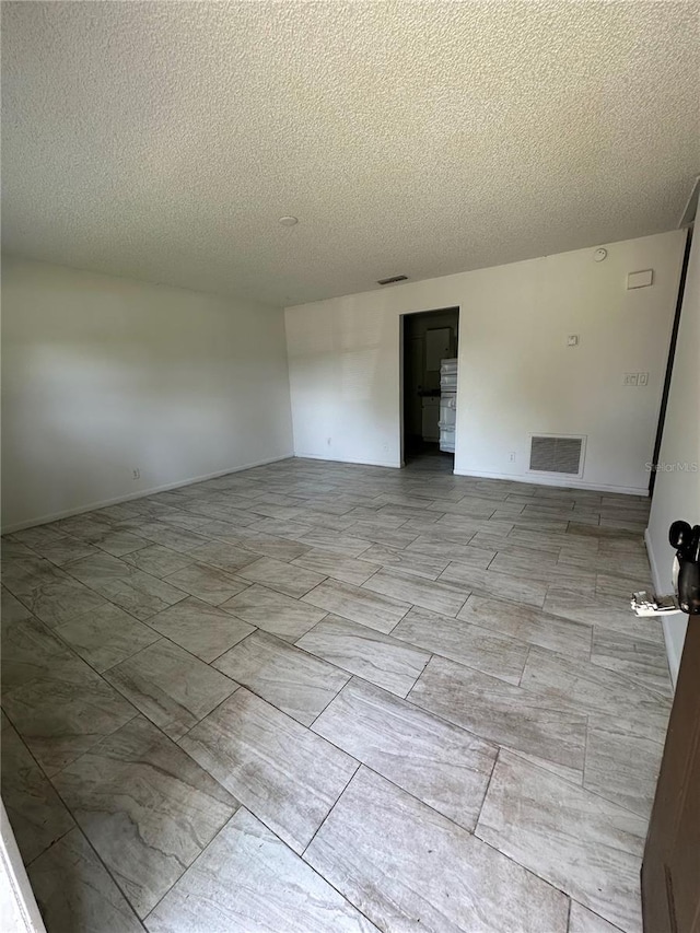 unfurnished room with a textured ceiling