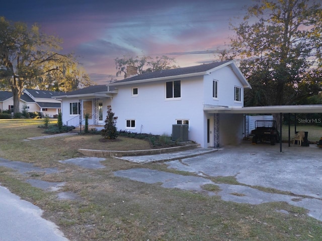 view of front of home with a carport and central air condition unit