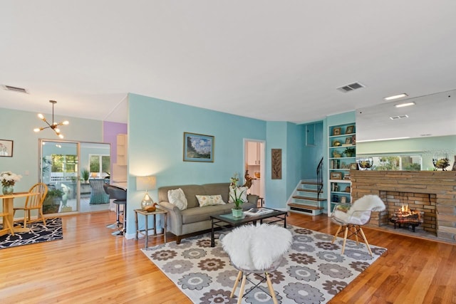 living room featuring a chandelier, light hardwood / wood-style floors, and a fireplace