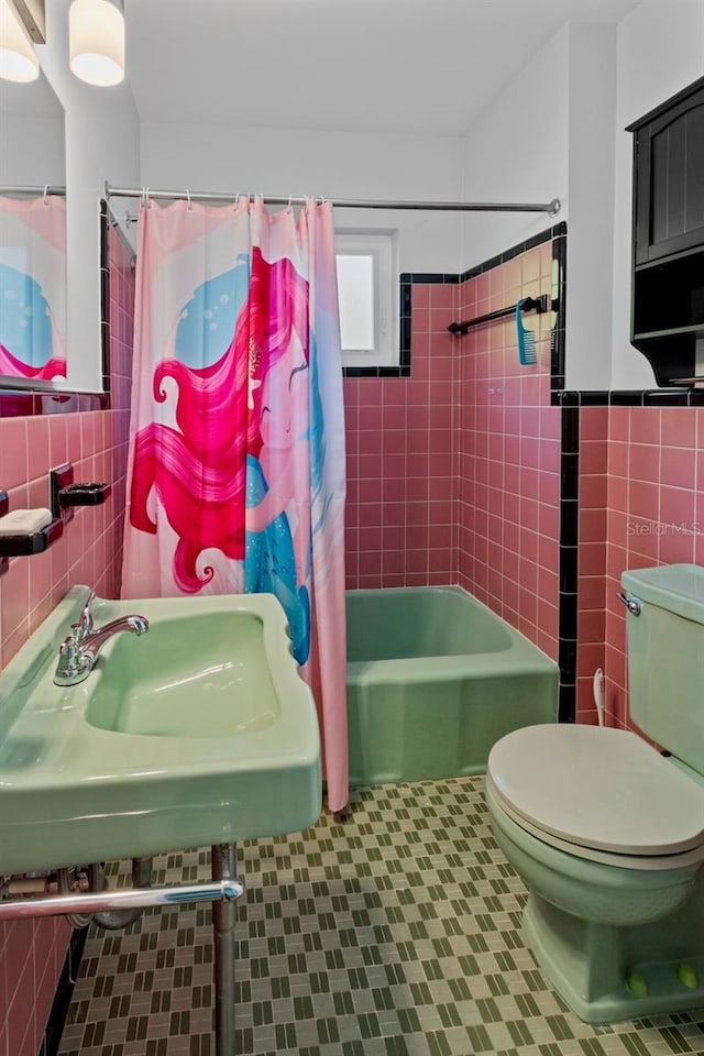 full bathroom featuring shower / bath combo, toilet, tile walls, and sink