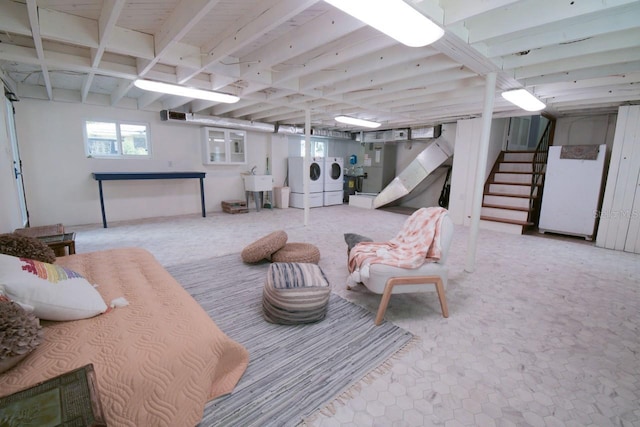 basement featuring separate washer and dryer, sink, and white refrigerator