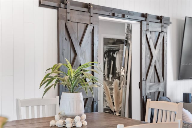 interior space featuring a barn door and wooden walls