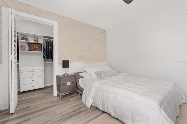 bedroom featuring ceiling fan, a closet, and light wood-type flooring