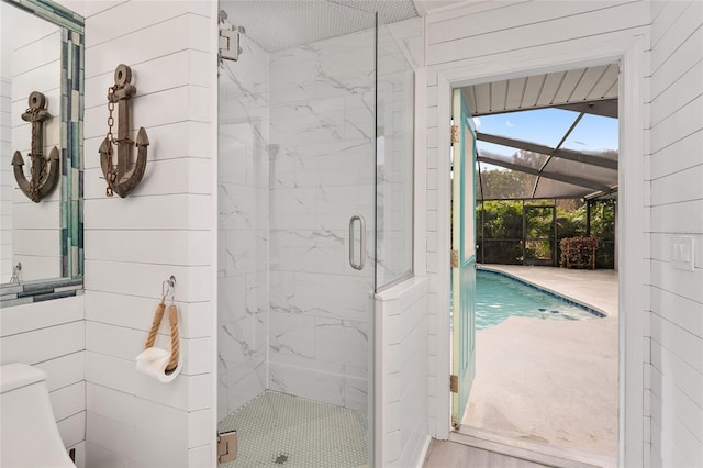 bathroom featuring toilet, a shower with shower door, and wood-type flooring