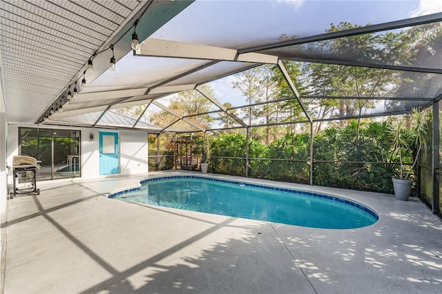 view of pool featuring glass enclosure and a patio area