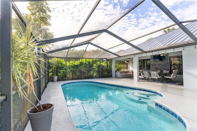 view of swimming pool featuring outdoor lounge area, ceiling fan, a patio area, and a lanai