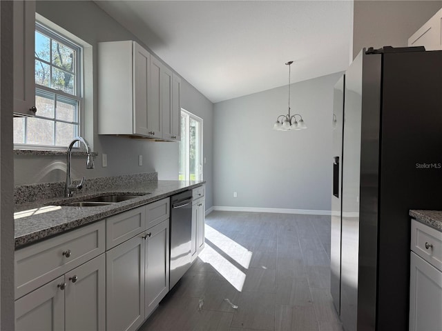 kitchen featuring white cabinetry, sink, lofted ceiling, stone countertops, and appliances with stainless steel finishes