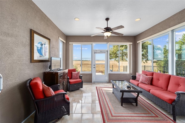 sunroom featuring ceiling fan and a wealth of natural light