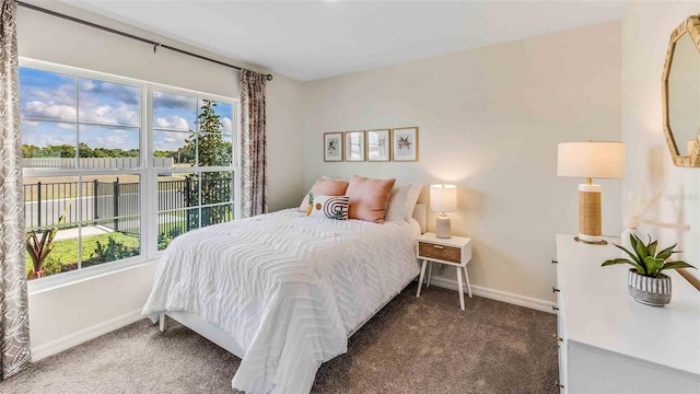 bedroom with multiple windows and dark carpet