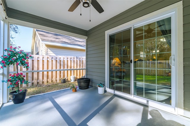 unfurnished sunroom featuring ceiling fan