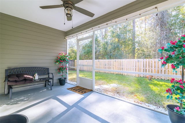 unfurnished sunroom featuring ceiling fan