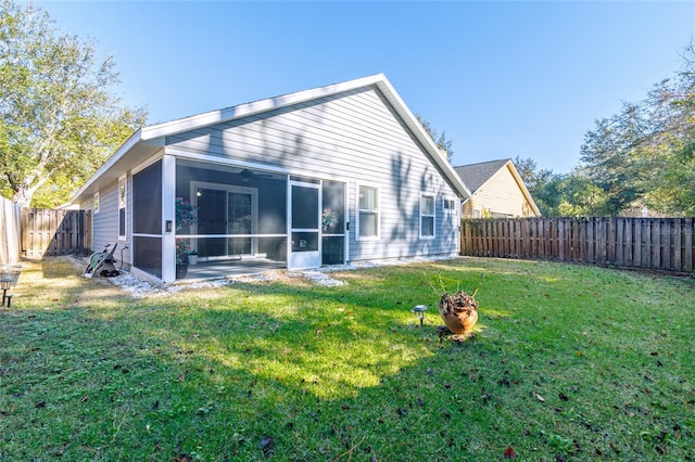 rear view of house featuring a sunroom and a yard