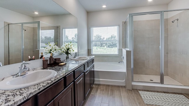 bathroom with hardwood / wood-style flooring, vanity, and shower with separate bathtub