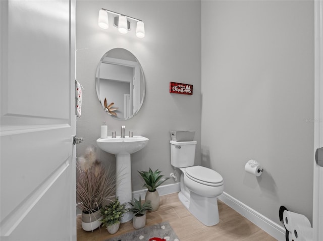 bathroom featuring hardwood / wood-style flooring, sink, and toilet