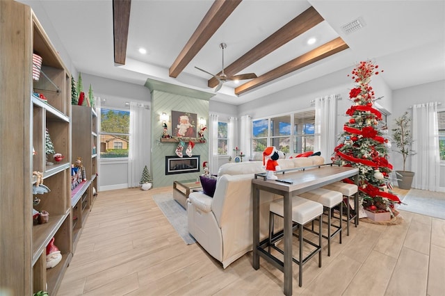 living room with a fireplace, plenty of natural light, and light wood-type flooring