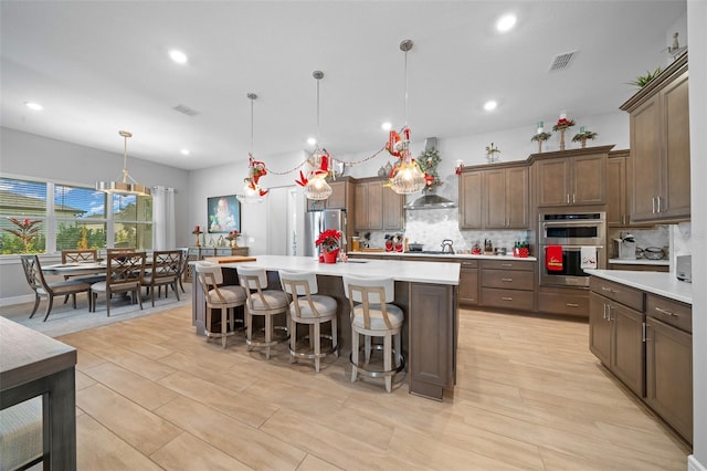 kitchen featuring stainless steel appliances, a center island, pendant lighting, and a kitchen breakfast bar