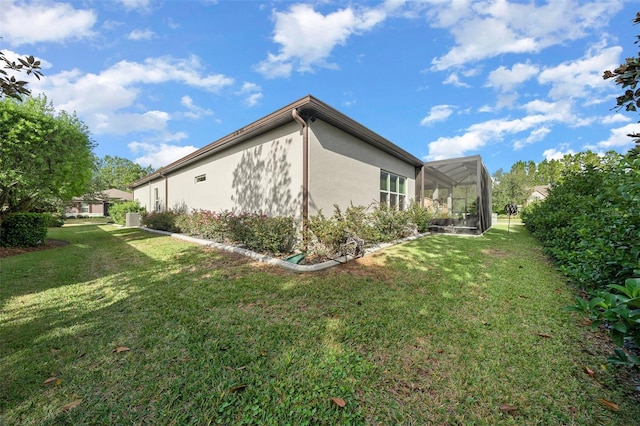 view of home's exterior with a lanai and a lawn