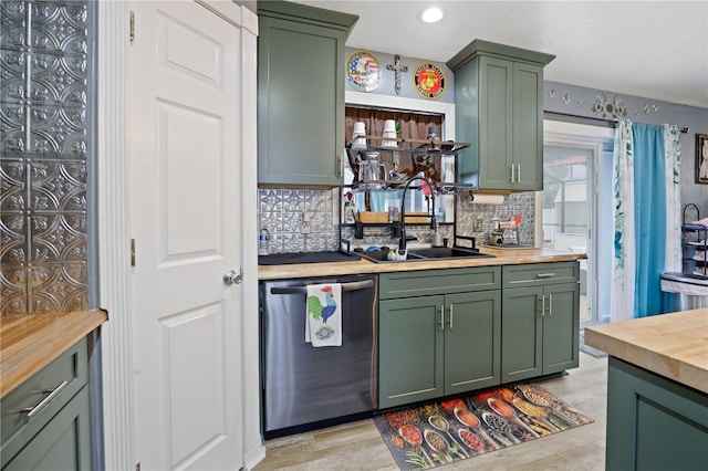 kitchen with butcher block countertops, sink, decorative backsplash, stainless steel dishwasher, and green cabinetry