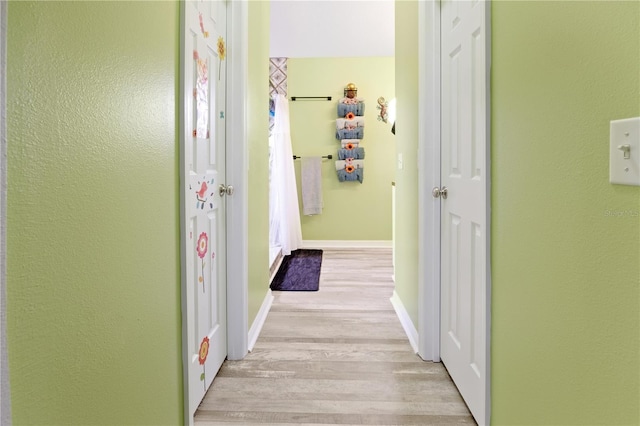 corridor with light hardwood / wood-style floors