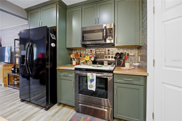 kitchen with stainless steel appliances, green cabinets, backsplash, and light wood-type flooring